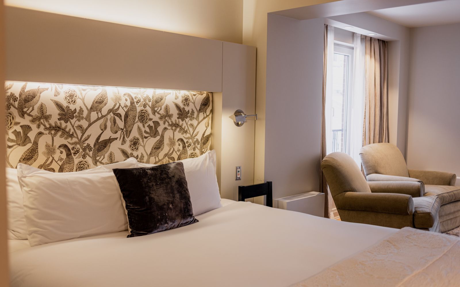 A Bedroom With A Bed And Chairs