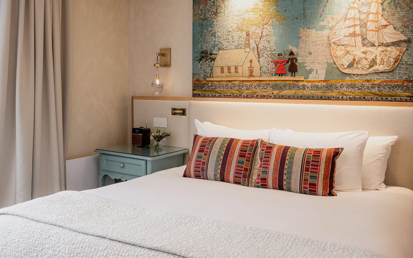 A Bed With A Painting On The Wall